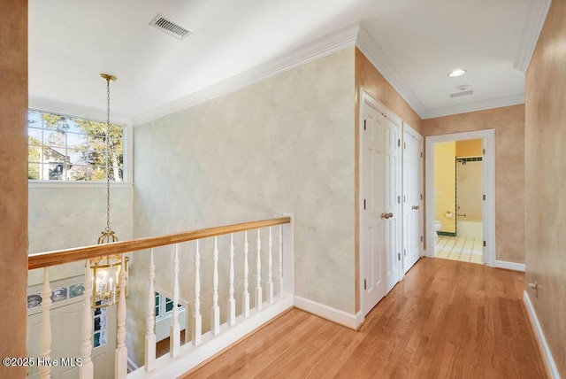 hallway featuring ornamental molding, a notable chandelier, and wood-type flooring