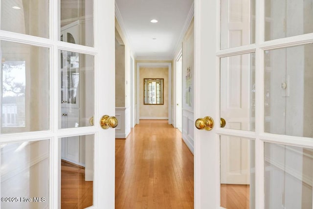 hallway featuring crown molding and light wood-type flooring