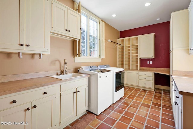 laundry area featuring cabinets, washing machine and dryer, light tile patterned floors, and sink