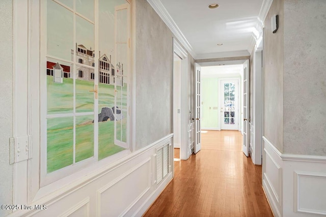 hall featuring french doors, wood-type flooring, and ornamental molding