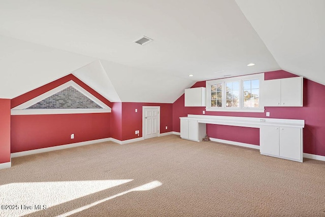 additional living space featuring light carpet and lofted ceiling