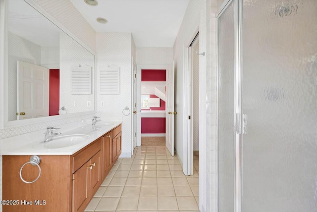 bathroom with tile patterned flooring, vanity, and walk in shower