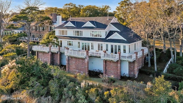 rear view of property featuring a balcony, a water view, and central air condition unit