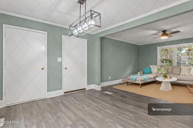 foyer entrance with ceiling fan, ornamental molding, and hardwood / wood-style flooring