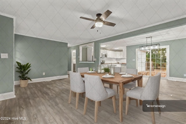 dining area featuring hardwood / wood-style flooring, ceiling fan, and crown molding