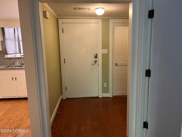 hall featuring sink, hardwood / wood-style floors, and a textured ceiling