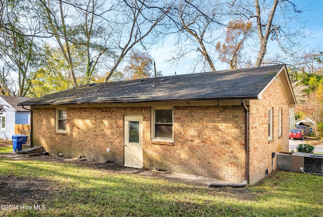 rear view of property featuring a lawn