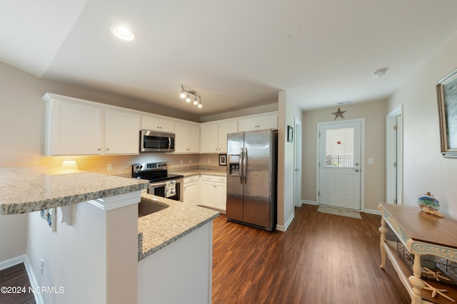 kitchen featuring kitchen peninsula, appliances with stainless steel finishes, dark hardwood / wood-style flooring, white cabinetry, and a breakfast bar area