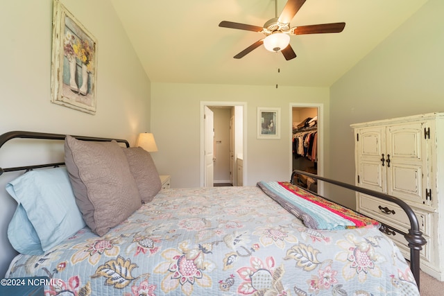 carpeted bedroom with a walk in closet, a closet, ceiling fan, and lofted ceiling