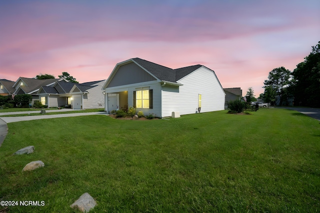 view of front of property with concrete driveway, an attached garage, and a front lawn