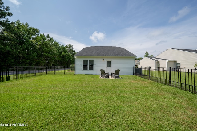 rear view of property with a fenced backyard, a garage, and a yard