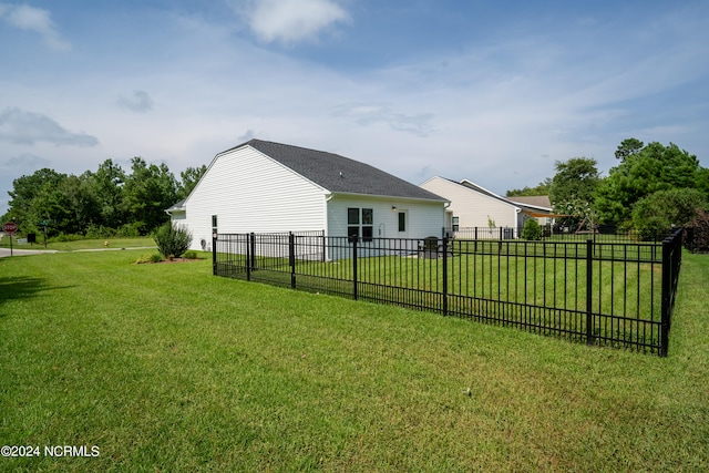 rear view of property featuring a yard and fence