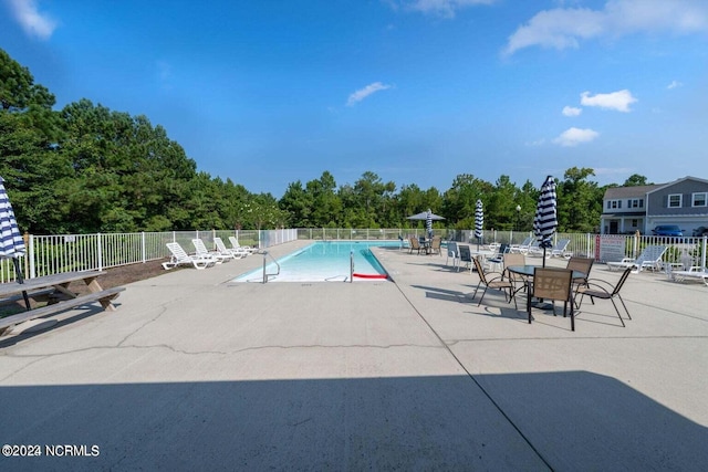 pool with a patio area and fence