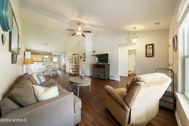 living area featuring visible vents, baseboards, ceiling fan, dark wood finished floors, and high vaulted ceiling