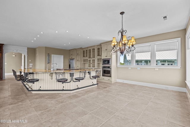 10108 Sea Breeze Dr, Emerald Isle, NC 28594 - kitchen featuring stainless steel appliances, a chandelier, a breakfast bar area, recessed lighting, and cream cabinetry