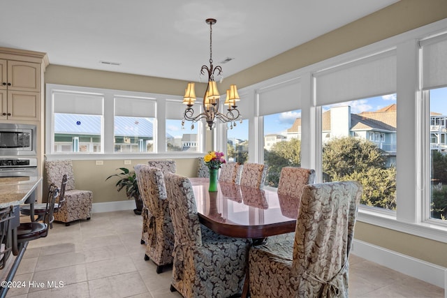 tiled dining area with a chandelier