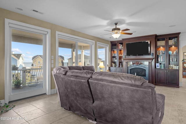 tiled living room with ceiling fan and plenty of natural light