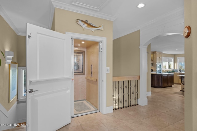 hall featuring ornate columns, ornamental molding, and light tile patterned flooring