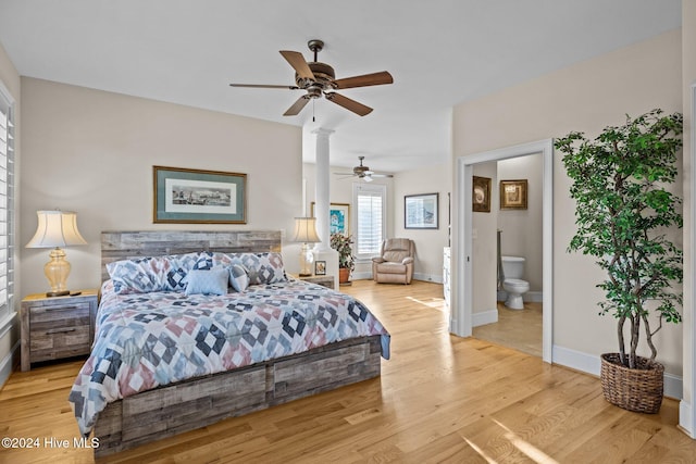 bedroom featuring connected bathroom, ceiling fan, light hardwood / wood-style floors, and ornate columns