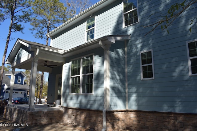 exterior space featuring ceiling fan and a garage