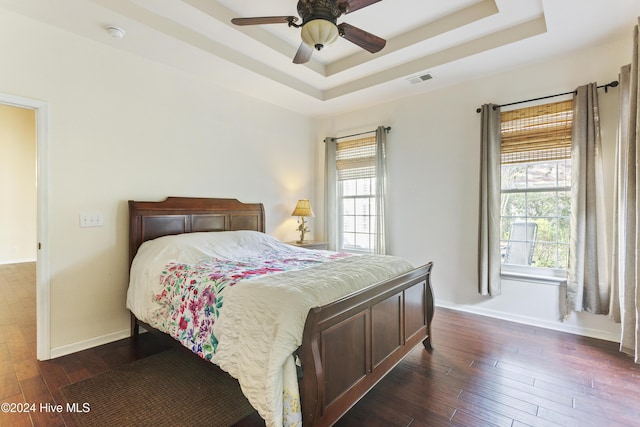 864 Sandpiper Bay Dr SW, Sunset Beach, NC 28468 - bedroom with a raised ceiling, dark wood-style floors, multiple windows, and ceiling fan
