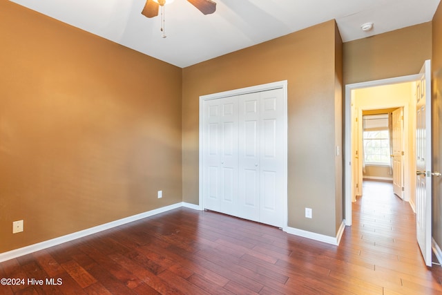 unfurnished bedroom with hardwood / wood-style floors, a closet, and ceiling fan