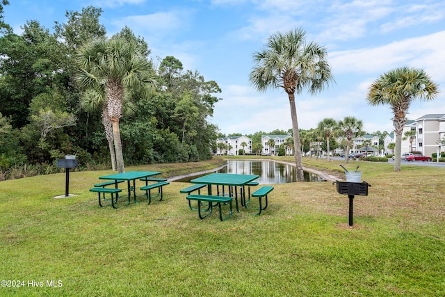 view of community featuring a yard and a water view