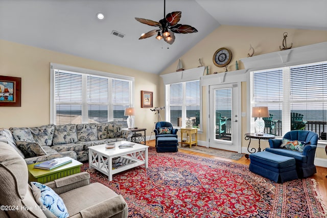 living room with ceiling fan, hardwood / wood-style floors, a healthy amount of sunlight, and lofted ceiling