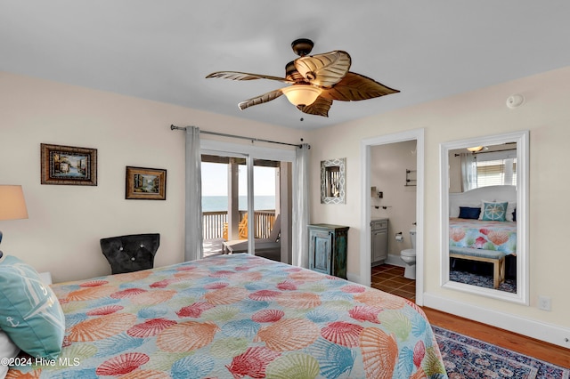 bedroom featuring a water view, ensuite bath, ceiling fan, access to exterior, and wood-type flooring