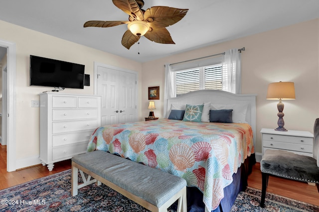 bedroom with a closet, hardwood / wood-style flooring, and ceiling fan