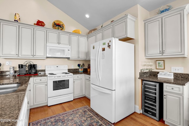 kitchen with vaulted ceiling, wine cooler, light hardwood / wood-style flooring, and white appliances