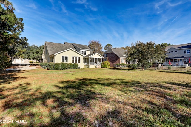 view of front of property with a sunroom and a front yard