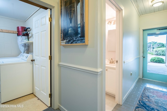 laundry area featuring washer / dryer, ornamental molding, and sink