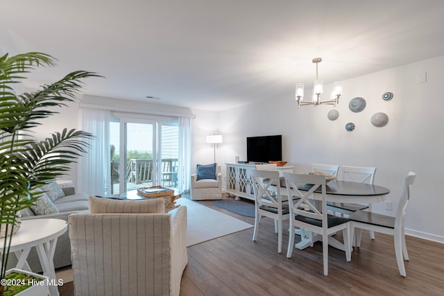 dining area featuring hardwood / wood-style flooring and a chandelier