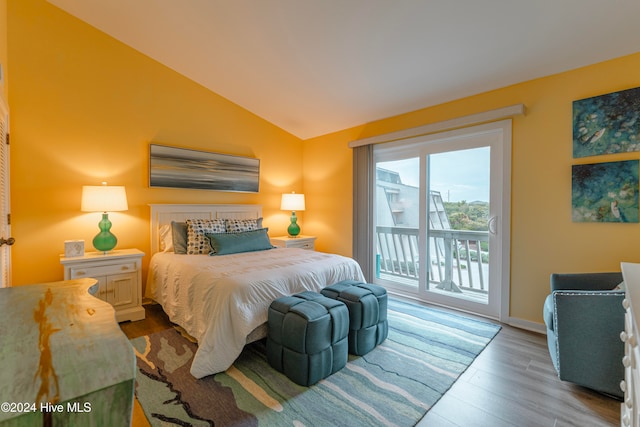 bedroom featuring access to exterior, light hardwood / wood-style floors, and vaulted ceiling