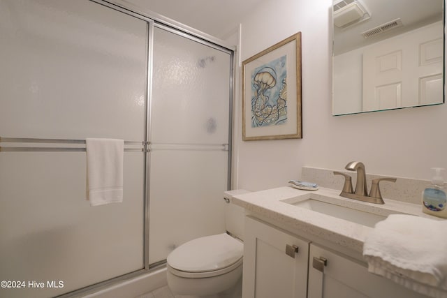 bathroom featuring vanity, toilet, and an enclosed shower