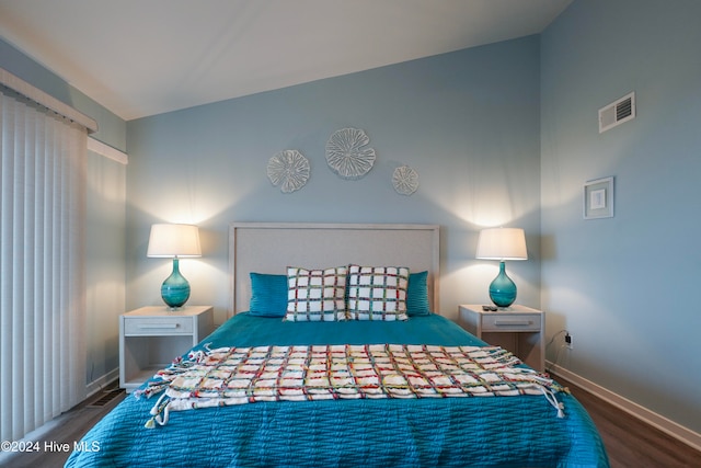 bedroom with hardwood / wood-style flooring and lofted ceiling