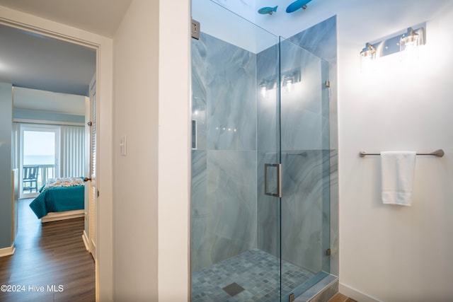 bathroom with wood-type flooring and a shower with door