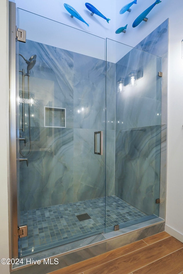 bathroom featuring a shower with door and wood-type flooring