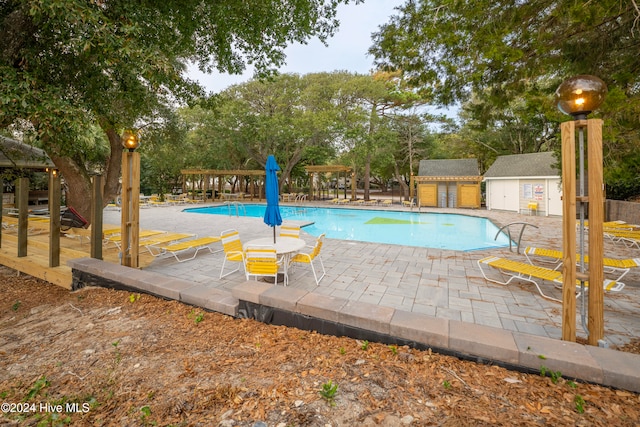 view of swimming pool featuring an outdoor structure and a patio