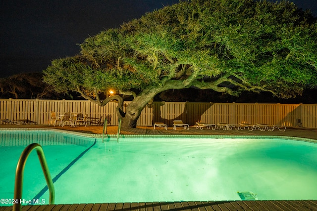 view of pool at twilight