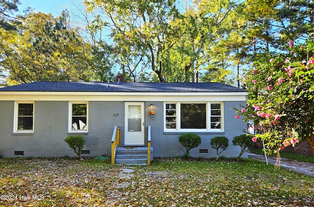 single story home featuring brick siding, crawl space, and a front yard