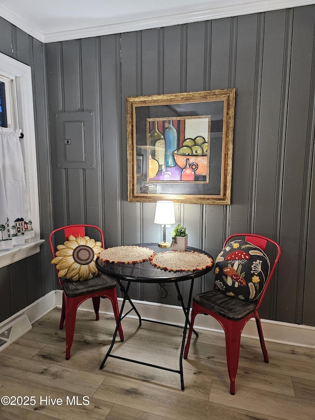 sitting room featuring electric panel, visible vents, baseboards, and wood finished floors