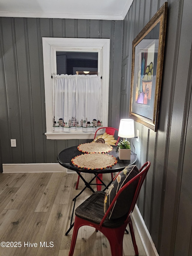 dining room featuring baseboards, wood finished floors, and crown molding