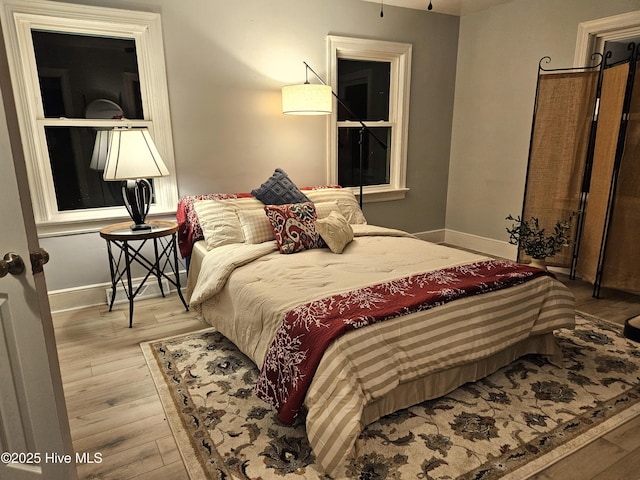 bedroom with baseboards and wood finished floors