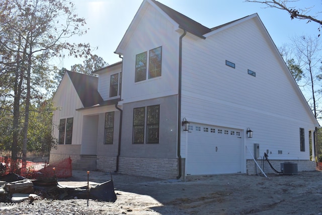 view of home's exterior with cooling unit and a garage