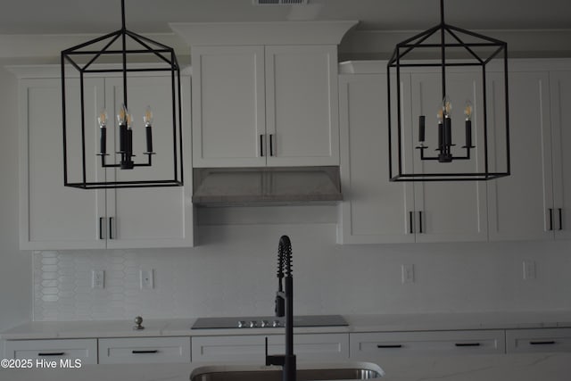 kitchen with decorative backsplash, light stone countertops, white cabinetry, and wall chimney exhaust hood