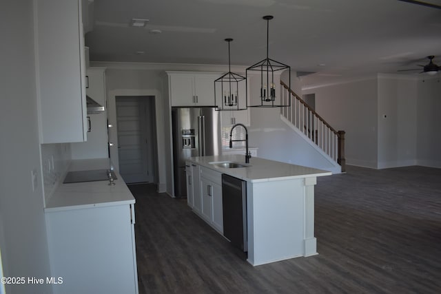 kitchen with pendant lighting, white cabinets, black appliances, sink, and a center island with sink