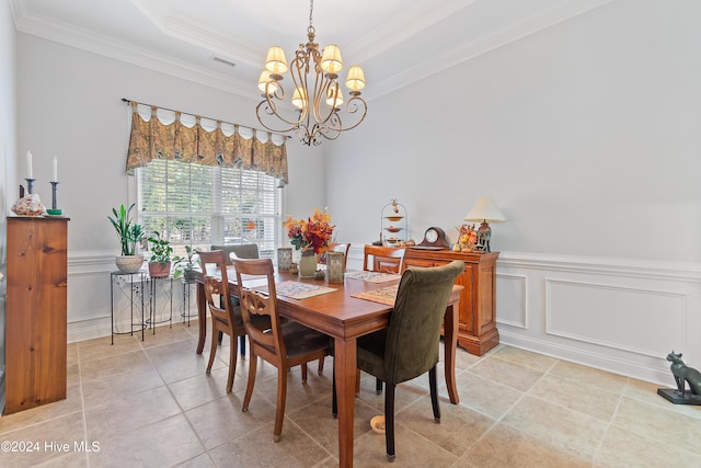 dining room with a raised ceiling, a chandelier, and ornamental molding