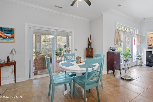 dining room featuring crown molding, plenty of natural light, ceiling fan, and light tile patterned floors